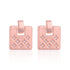 Pair of pink earrings with star designs on a white background