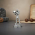 Metallic superhero figurine holding a hammer on a dark surface with a neutral background
