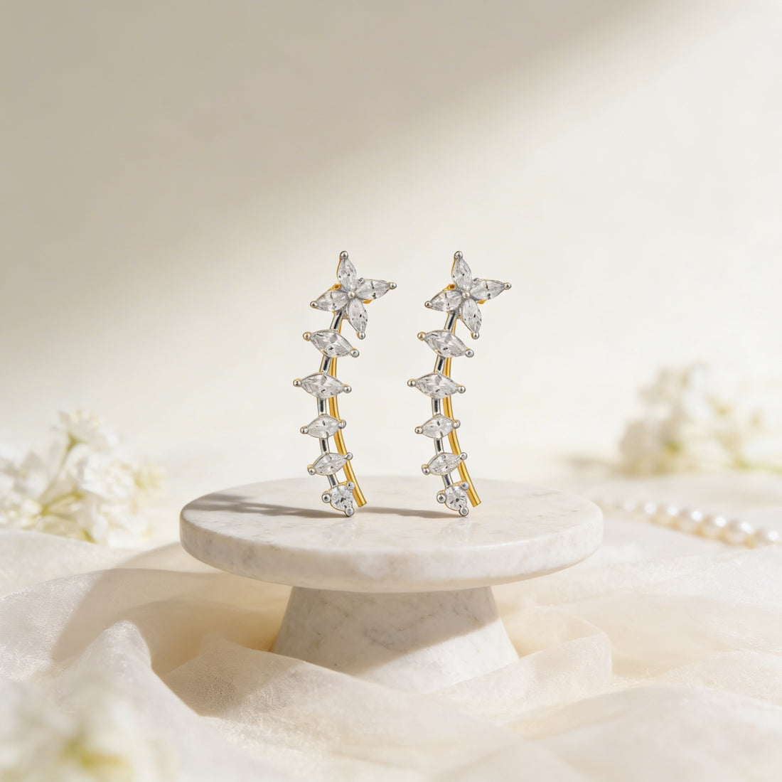 Star-shaped earrings on a marble stand with a soft floral background