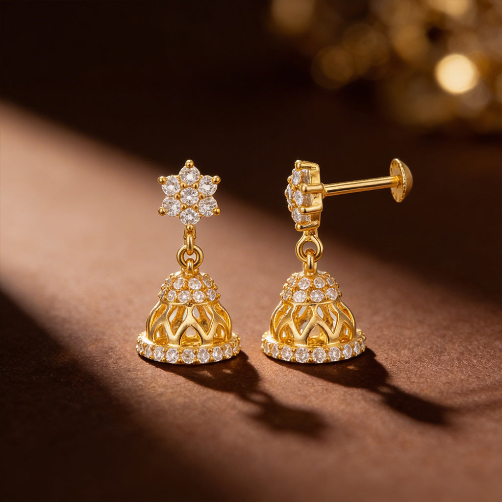 Gold earrings with diamond accents on a brown surface