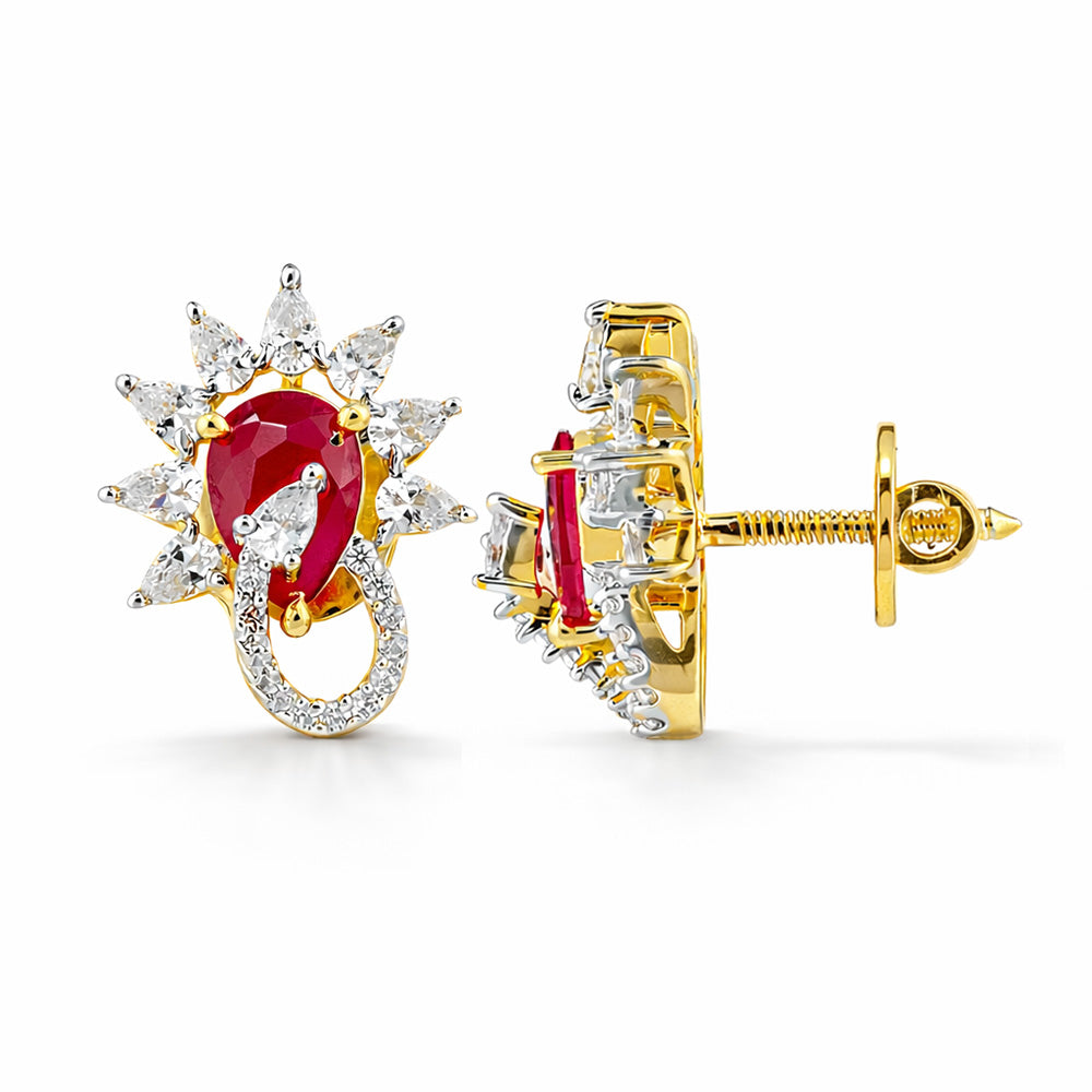 Gold earrings with a central red gemstone and diamond accents on a white background