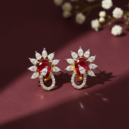 Pair of earrings with red gemstones and diamond-like stones on a maroon background