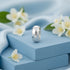 Silver ring on a blue surface with white flowers