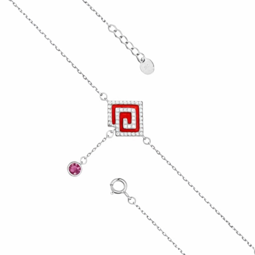 Silver necklace with a red square pendant and pink gemstone on a white background