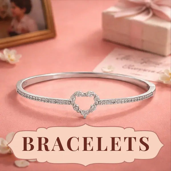 Silver bracelet with heart design on a pink surface, labeled 'BRACELETS'.
