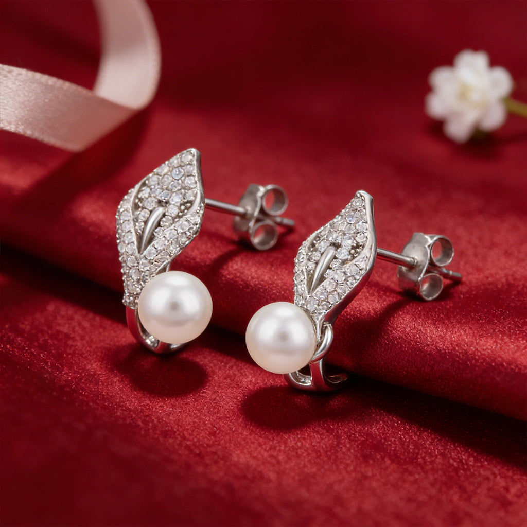 Silver leaf earrings with pearls on a red fabric background