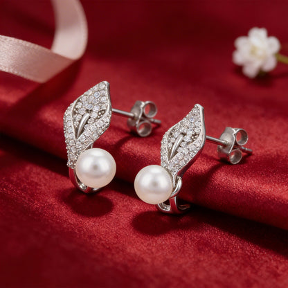 Silver leaf earrings with pearls on a red fabric background