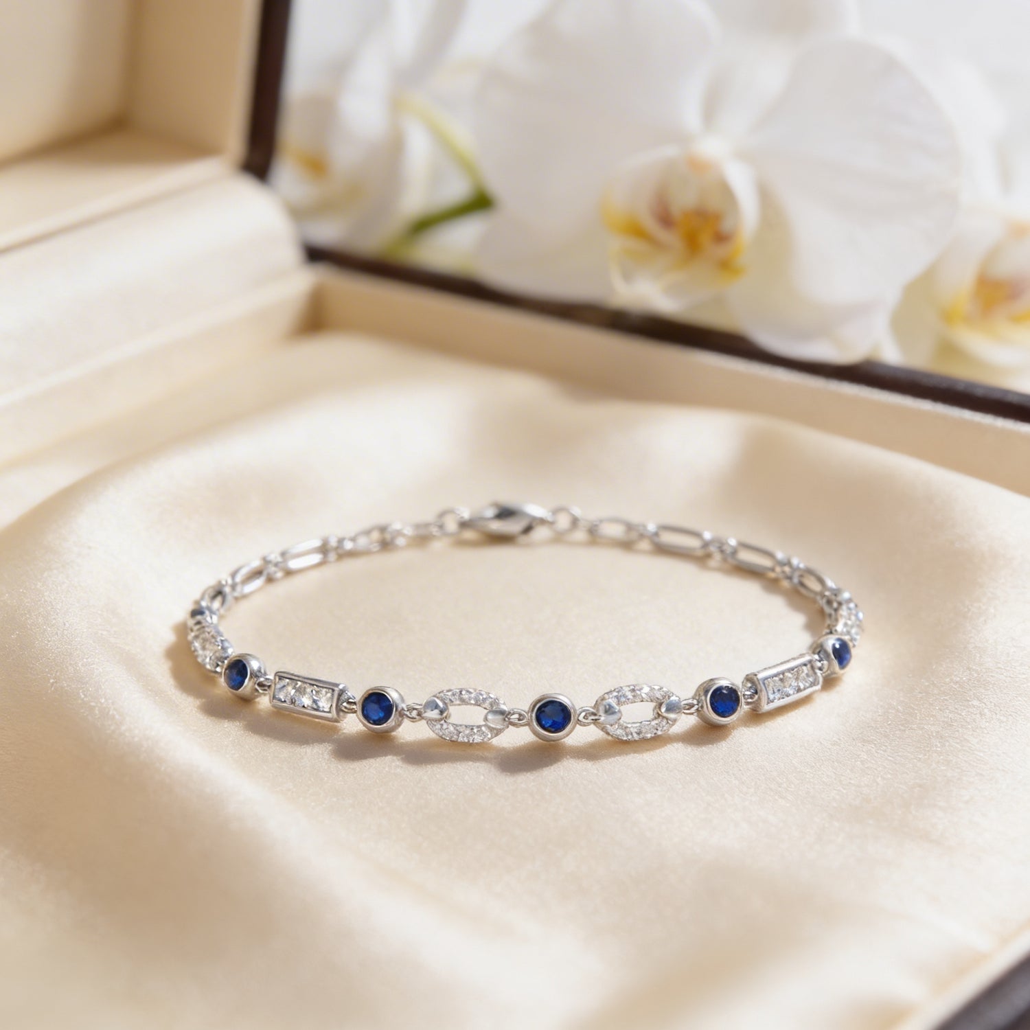 Silver bracelet with blue stones on a beige fabric background