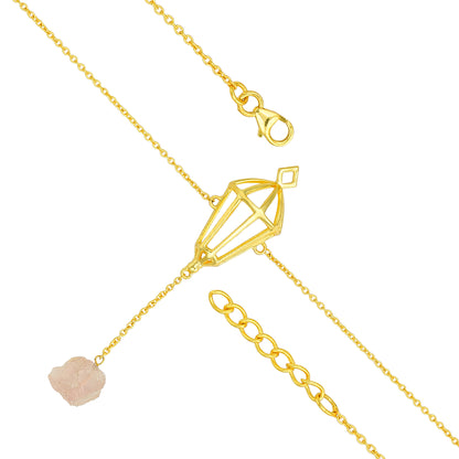 Gold necklace with a diamond-shaped pendant and pink stone on a white background