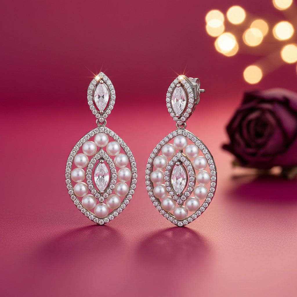 Pearl and crystal earrings on a pink background with blurred lights and a rose.