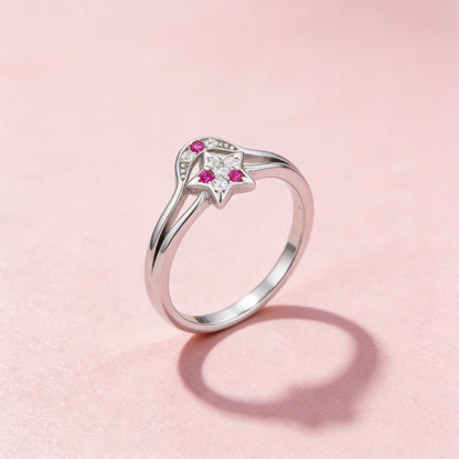 Silver ring with pink gemstones on a pink background