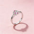Silver ring with pink gemstones on a pink background