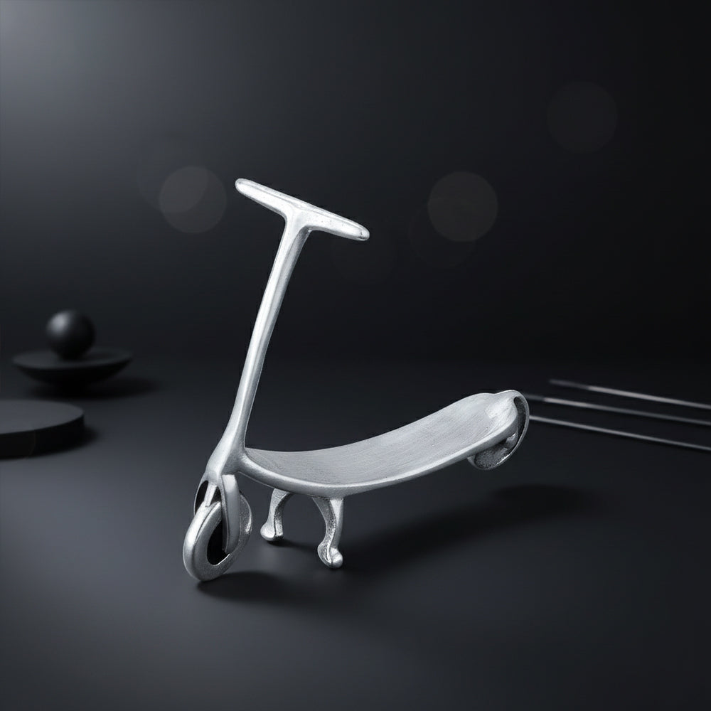 Silver scooter-shaped object on a dark background