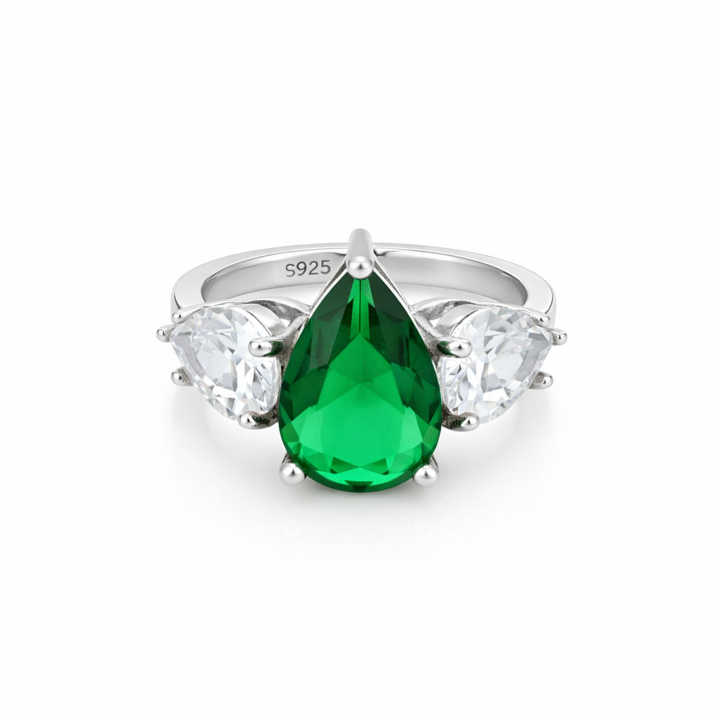 Silver ring with a green teardrop gemstone and clear side stones on a white background