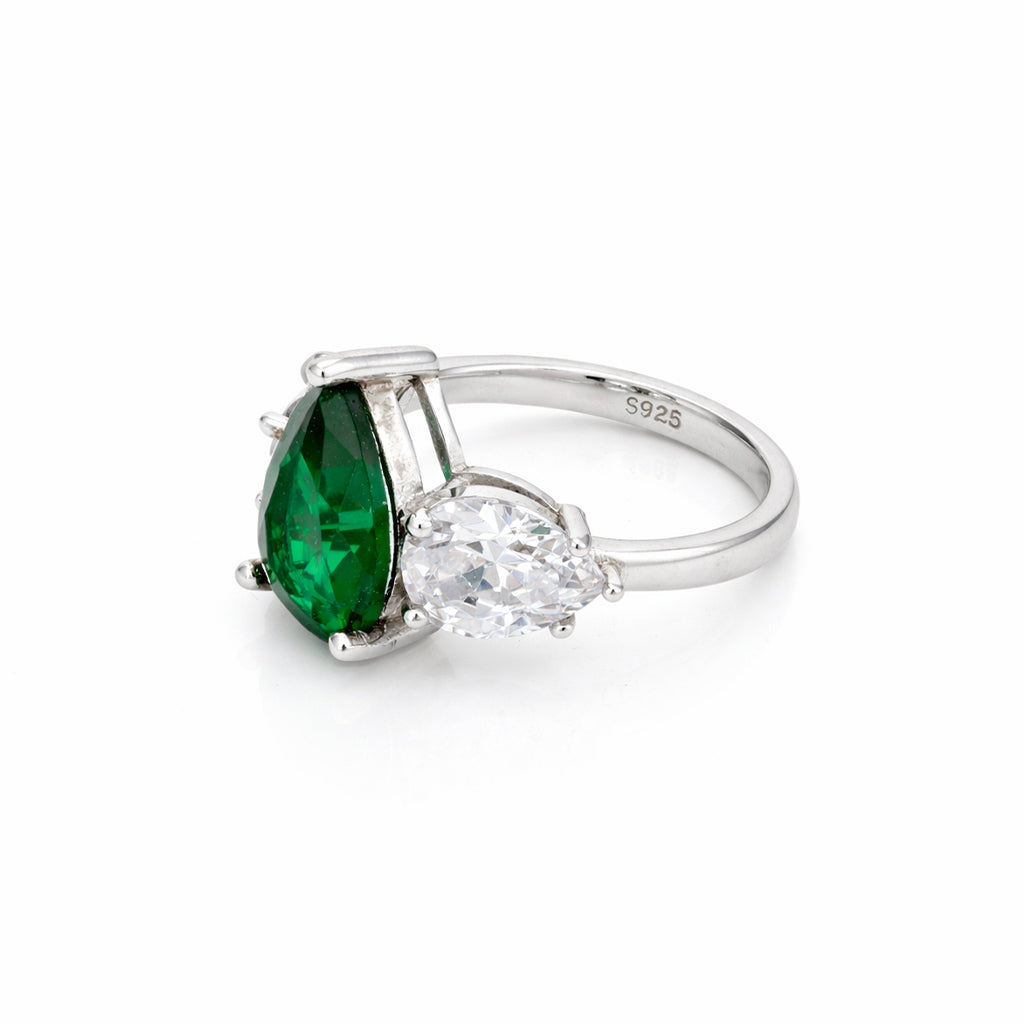 Silver ring with a green gemstone and clear stone on a white background