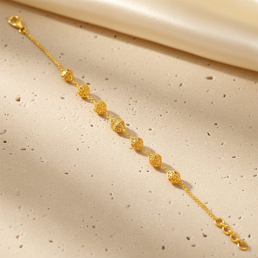 Gold bracelet on a beige fabric background