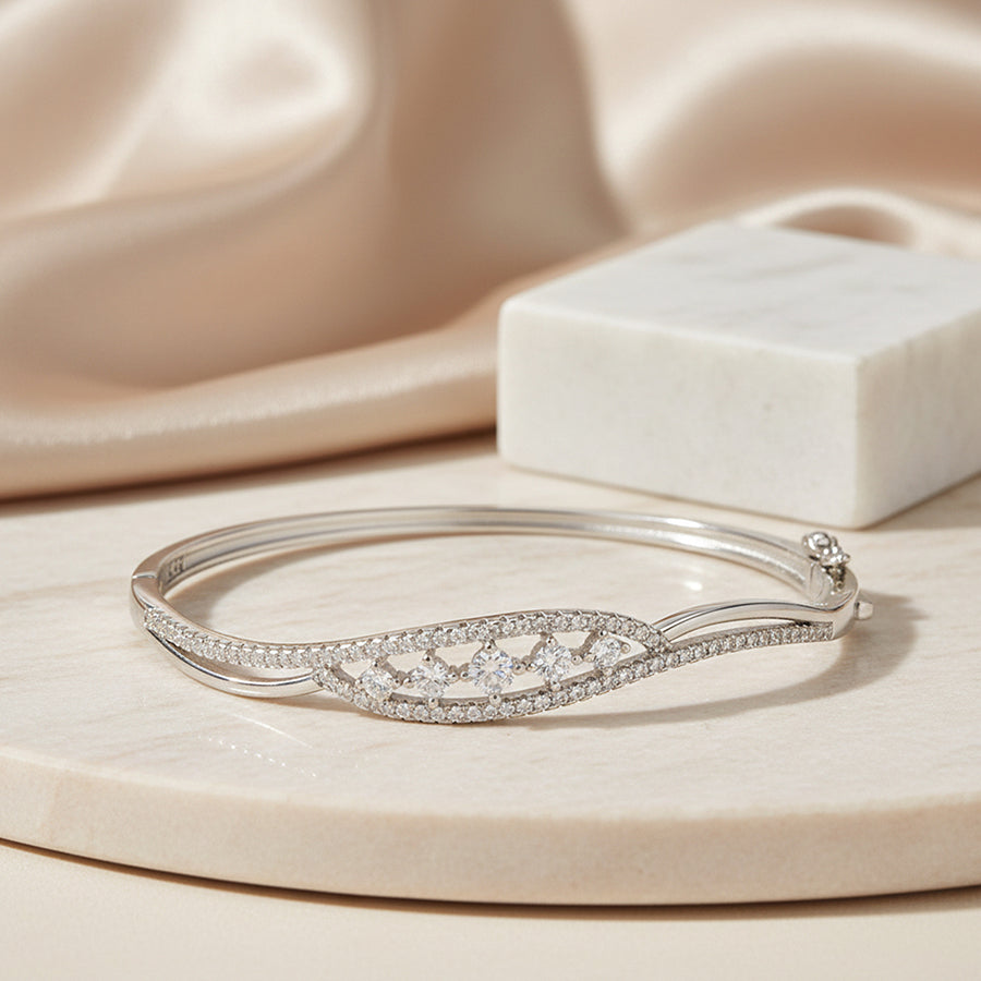 Silver bracelet with diamond accents on a beige surface