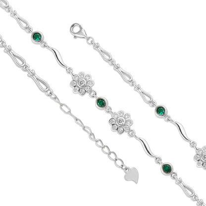 Silver bracelet with green gemstones and floral designs on a white background