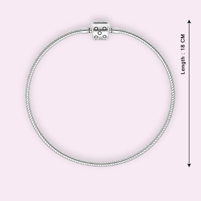 Silver bracelet with a clasp on a light pink background